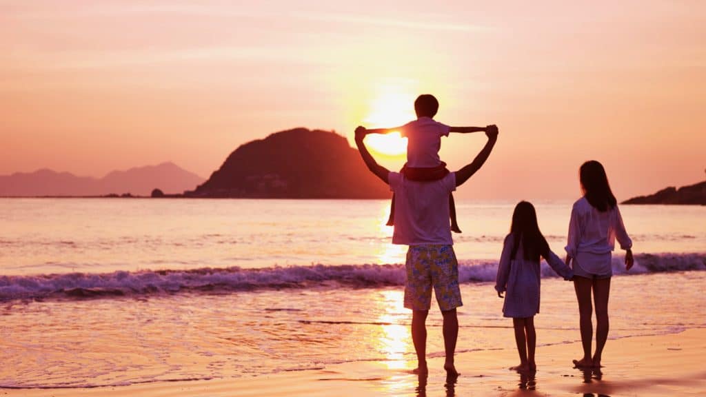 Famille sur la plage admirant le coucher de soleil